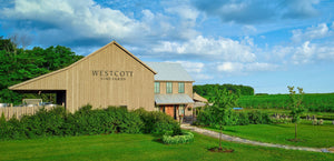 A wide shot of the Westcott Vineyards winery, with gree vineyards visible in the background. 