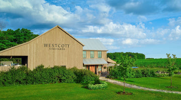 A wide shot of the Westcott Vineyards winery, with gree vineyards visible in the background. 