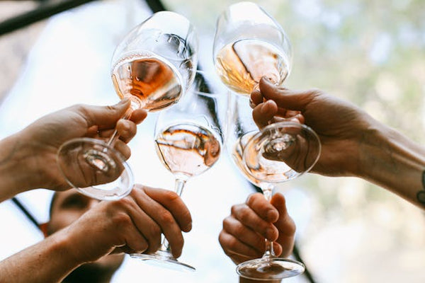 Four glasses of rose wine toast during a wine tasting experience. 